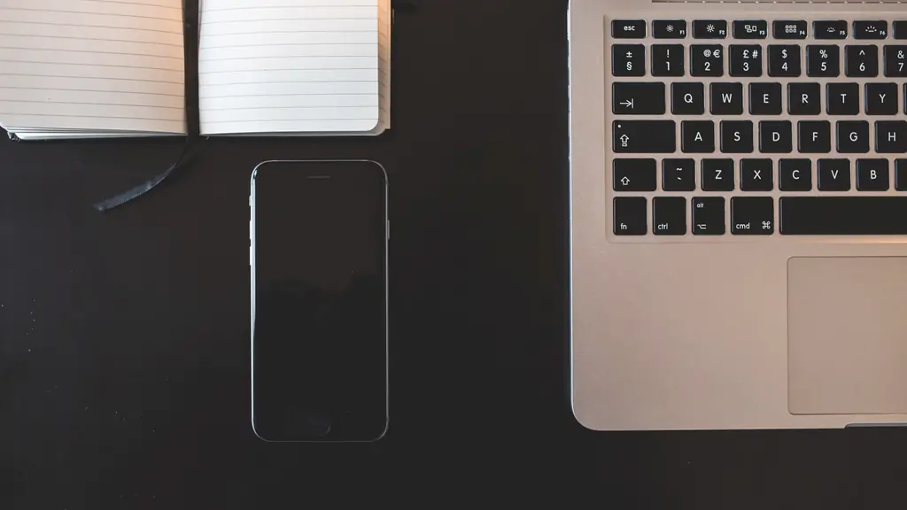 Escritorio oscuro con notebook, celular y libreta: las herramientas digitales básicas de una pyme