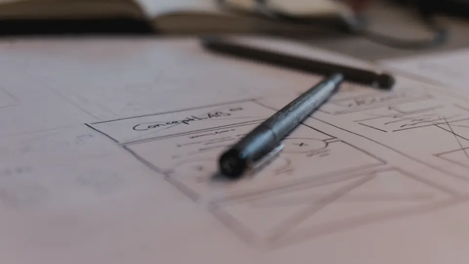 Boceto de un sitio web en papel con una lapicera, la etapa en que se evalúa una propuesta