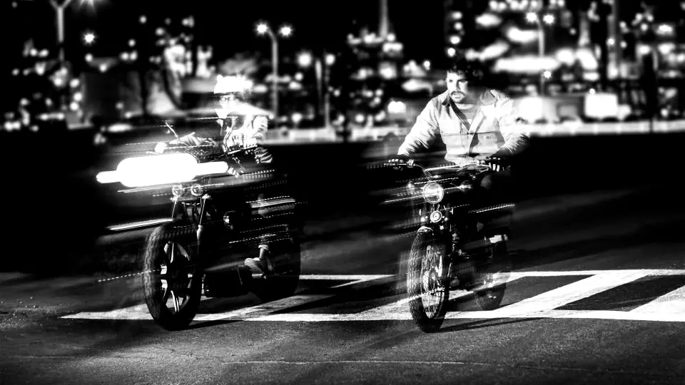 Motos circulando de noche por la ciudad en blanco y negro