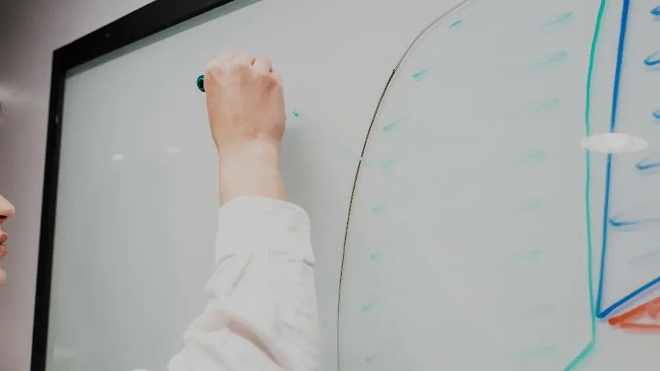 Mano dibujando un flujo de proceso en una pizarra