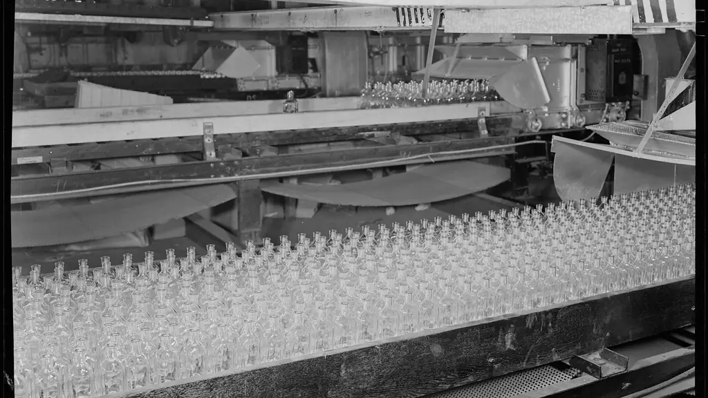 Línea de producción con botellas sobre una cinta transportadora en blanco y negro