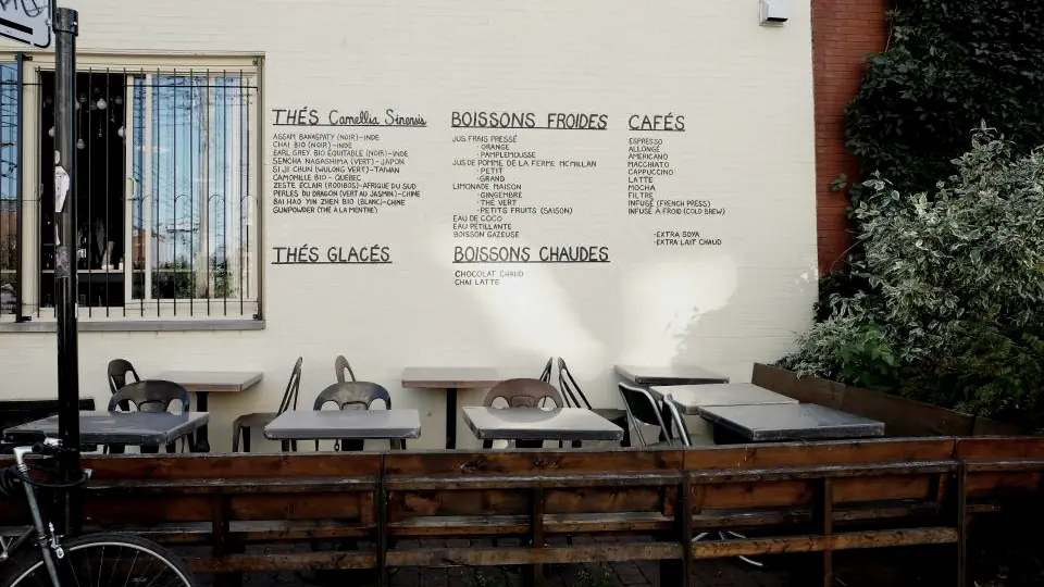 Interior de un café con la carta escrita en la pared